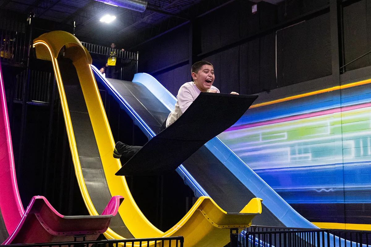 child going down mega launch slide