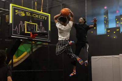 teen dunking basketball at Slick City Action Park Sport Air Court